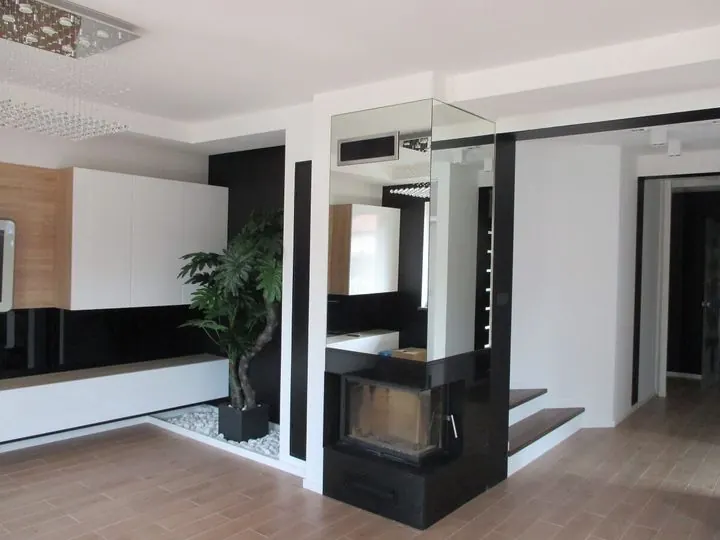 Salon z narożnym kominkiem w czarnej zabudowie i lustrem – Mieszkanie, ul. Stare Wiślisko, Kraków